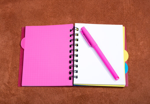 Open notebook with pink bookmark on a pink background