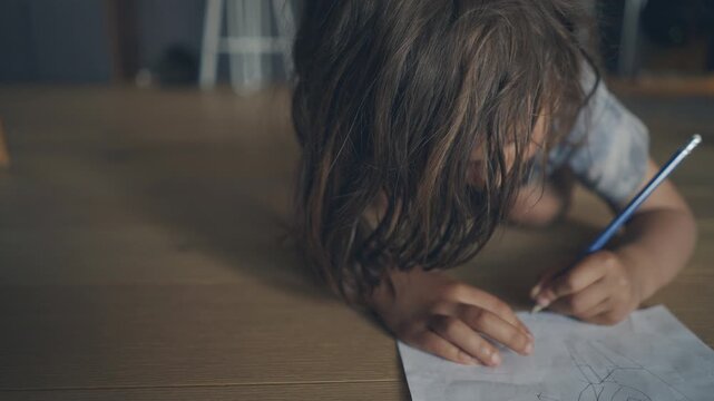 Extreme close-up of a child writing and drawing on paper