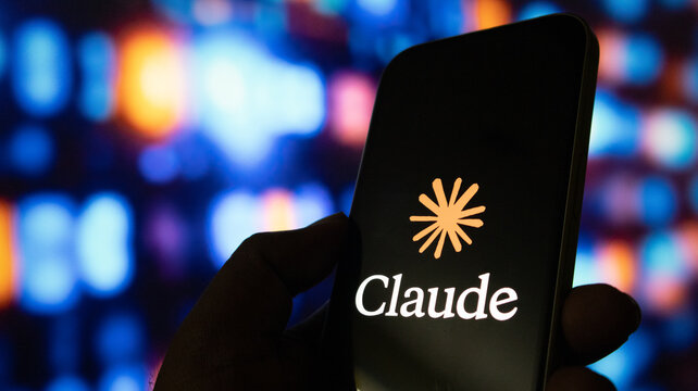 A close up shot of human hand holding smartphone with claude ai logo on black screen.