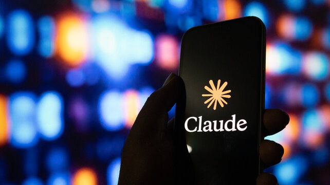 A close up shot of human hand holding smartphone with claude ai logo on black screen.