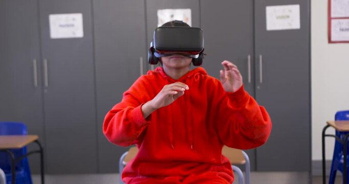 African American youth sitting in classroom chair, VR starting reaching pinching content to learn