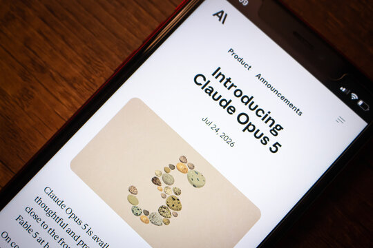 Mexico City, MEXICO - Jul 28 2026 : Close-up of a smartphone on a dark wooden table showing Anthropic's Introducing Claude Opus 5 announcement page, with an illustration.
