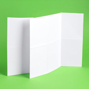 Folded blank white paper sheets arranged in a triptych isolated on a vibrant green studio background