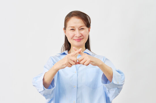 白背景でバツサインをする女性