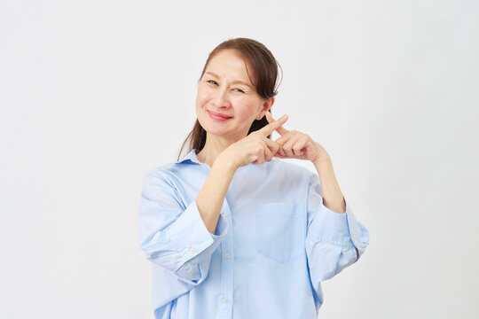 白背景でバツサインをする女性