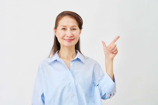 白背景でチェックサインをする女性