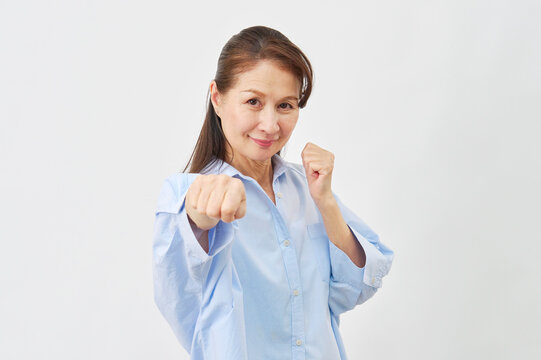 白背景でファイティングポーズをする女性