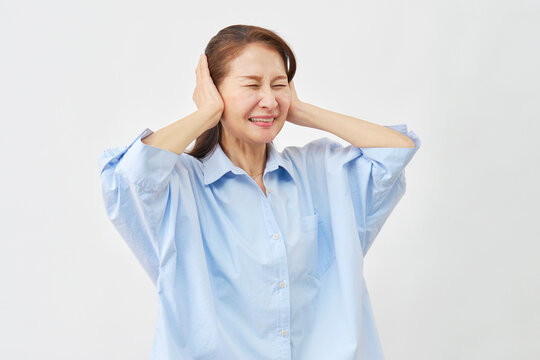 白背景で耳を塞ぐ高齢女性