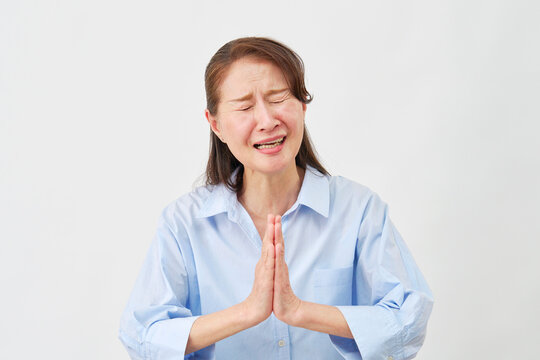 白背景で懇願する高齢女性