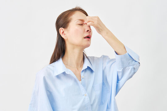 白背景で目頭を押さえる女性