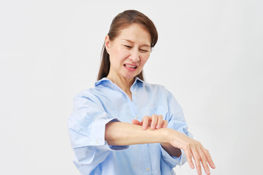 白背景で腕を掻く女性