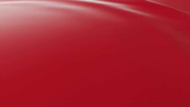 Abstract flowing liquid red texture with smooth wavy ripples and glossy satin finish creating a sense of movement and luxury in a professional studio lighting environment