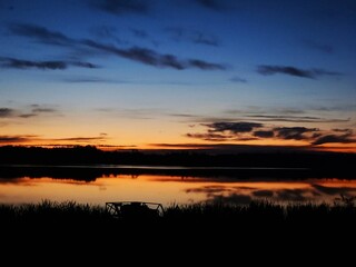 Fototapeta premium Lake Sunset Landscape with Deep Blue Twilight Sky and Orange Water Reflection