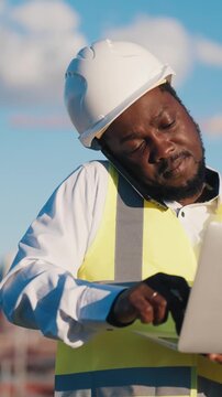 Audit and expertise in construction site, portrait of african american engineer. Professional builder working with laptop, making report about building works, architect control project implementation