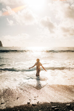 Woman with arms outstretched in the ocean surf