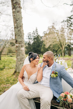 Bride affectionately touches groom's face outside