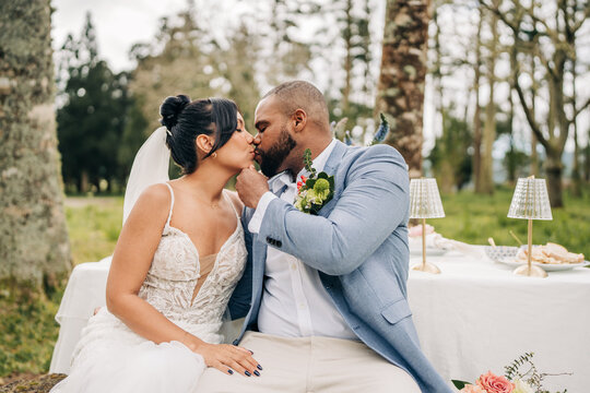 Newlywed couple share a romantic kiss outdoors