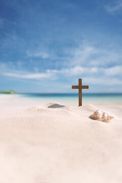Seashells and the Cross of Jesus Christ on a seaside beach, background for church summer camps, summer Bible school, and summer retreats.
