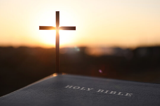 Silhouette of the Cross of Jesus Christ and the Bible, Christian faith and belief background
