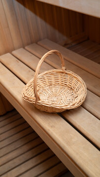 Empty wicker basket on wooden sauna bench interior design