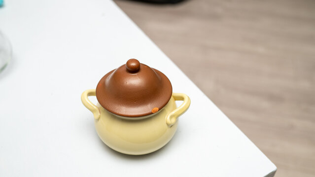 Ceramic soup pot with lid on white tabletop