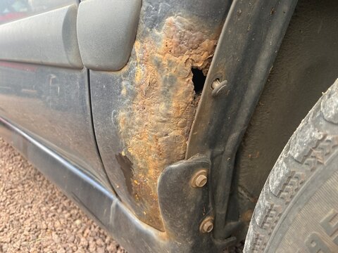 Starker Rostschaden am Radlauf eines &auml;lteren Autos. Korrosion, Durchrostung, Fahrzeugalterung, Karosserieschaden, Wartung, Reparatur und Werterhalt im Fokus.