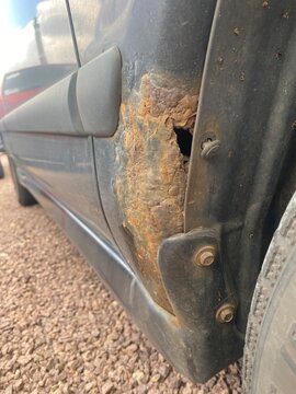 Starker Rostschaden am Radlauf eines &auml;lteren Autos. Korrosion, Durchrostung, Fahrzeugalterung, Karosserieschaden, Wartung, Reparatur und Werterhalt im Fokus.