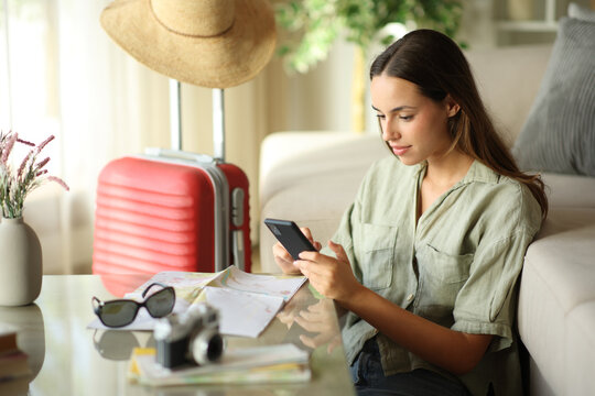Serious tourist using phone during vacation in apartment