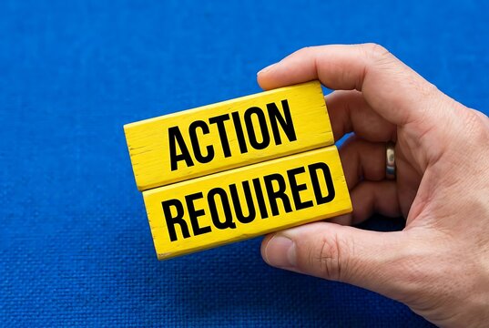Hand holding yellow blocks with 'Action Required' text, representing urgency and decision making.