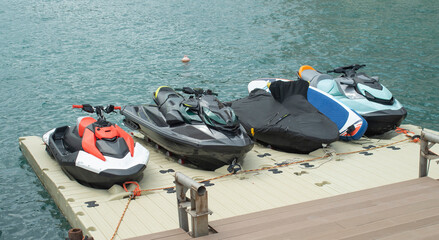Jet skis and a paddleboard docked on a floating plastic pontoon platform at sea © isabela66