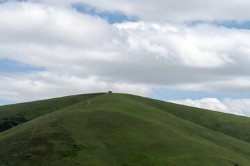 Fototapeta premium Green hill landscape with clouds and open sky