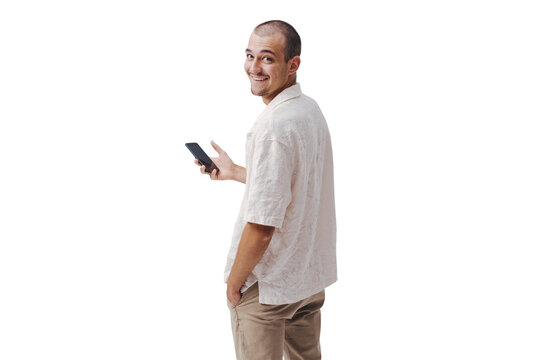 Smiling Young Man Holding Smartphone Looking Back Over Shoulder on Purple Background