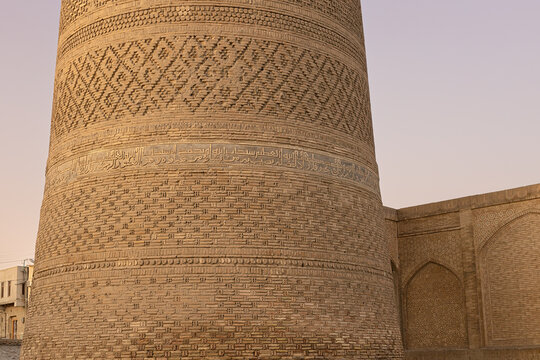 Kalyan Minaret brickwork detail with Arabic calligraphy bands at Poi Kalyan Square in Bukhara. Ideal for travel publications, cultural heritage materials, and architectural studies.