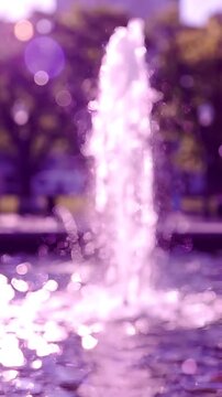 A Serene Water Fountain Surrounded by Nature, Capturing the Essence of Tranquility with Sparkling Water and Beautiful Bokeh Effects in a Dreamy Purple Hue
