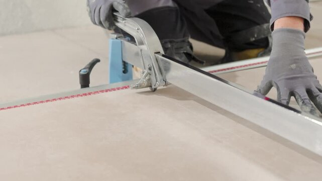 Professional tiler cutting a tile with a big cutting tool. Renovating your house.