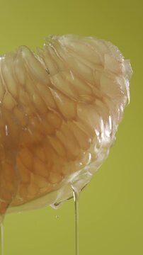 Grapefruit (pomelo) cut with dripping glycerin on a yellow background.