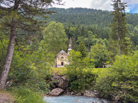 Mountain church by river in forest at Les Contamines-Montjoie, France