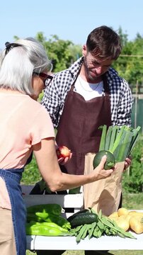 Farmer selling fresh organic vegetables at outdoor market stall