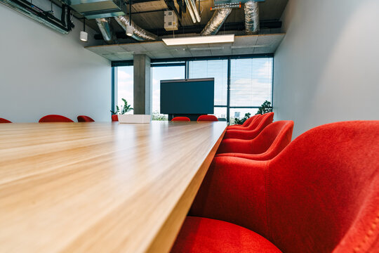 conference room wooden table red chairs empty screen mockup