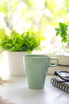 Good Morning with green cup coffee near window morning light for new life.  Goal life wellness Concept.