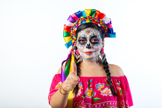 Woman with Colorful Catrina Makeup Giving Thumbs Up for Day of the Dead on Gray Background
