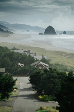 Cannon Beach seaside town houses with Haystack Rock in the background on a moody day, Oregon, Pacific Northwest, USA