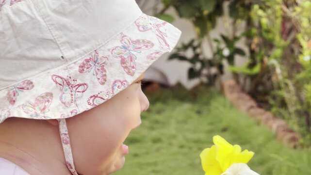Close-up of a crying toddler wearing a sun hat outdoors. Emotional child expressing distress, sadness and frustration in a natural daytime setting.