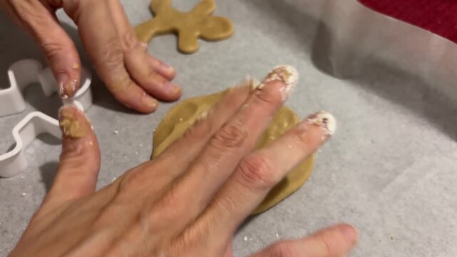 Manos extendiendo masa para galletas de Navidad