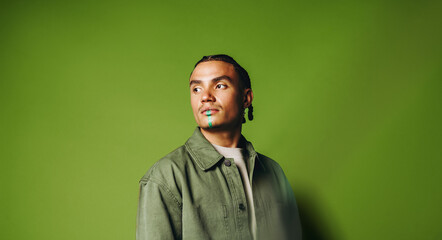 Fototapeta premium Artistic man portrait in the studio with face paint and braided style