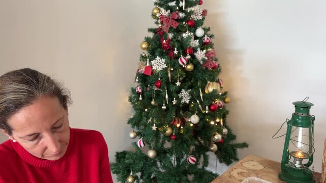 Tilt Down desde el &aacute;rbol hacia mujer preparando galletas de Navidad