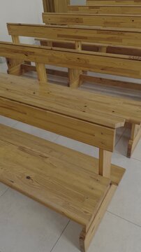 Church interior with rows of wooden pews and confessional booth in Catholic sanctuary.