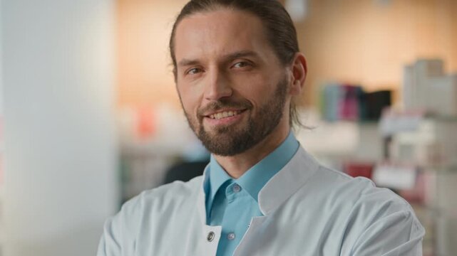 Portrait calm smiling Caucasian man pharmacist doctor in medical uniform in pharmacy male physician looking at camera working with health care problem illness pandemic in drugstore medicine clinic