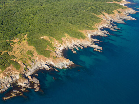 Aerial Top-Down View of Rocky Coastline and Deep Blue Sea Water