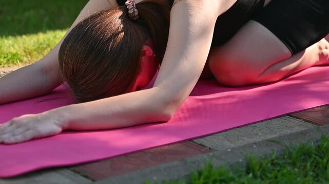 Woman practicing yoga pose on a fitness mat in a bright sunlit room, healthy lifestyle and wellness concept